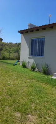 a house with a window and a grass yard at Casa los nonos in Cavalango