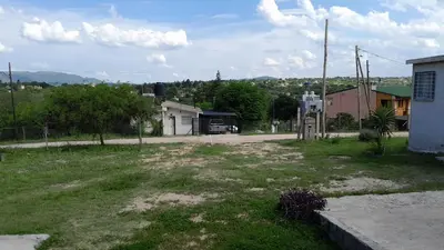 a field of grass with a building in the background at Monoambiente in Villa Parque Siquiman