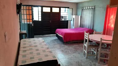a bedroom with a bed and a table and a table and chairs at Monoambiente in Villa Parque Siquiman