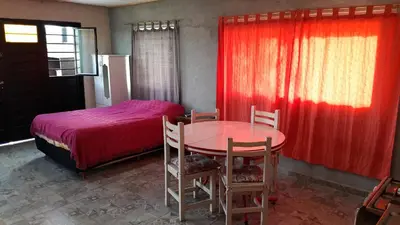 a bedroom with a bed and a table and chairs at Monoambiente in Villa Parque Siquiman