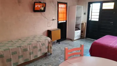 a room with a bed and a table and a tv at Monoambiente in Villa Parque Siquiman