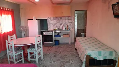 a small kitchen with a table and a refrigerator at Monoambiente in Villa Parque Siquiman