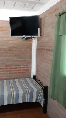 a room with a tv on a brick wall at Postal Serrana 2 in Villa Cura Brochero