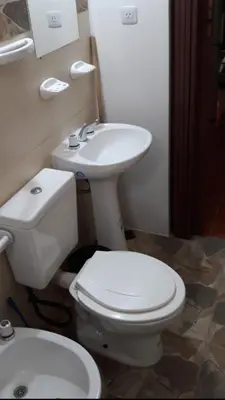 a bathroom with a white toilet and a sink at Postal Serrana 2 in Villa Cura Brochero