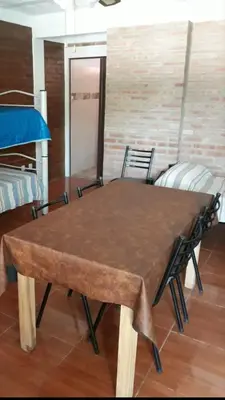 a wooden table in a room with chairs at Postal Serrana 2 in Villa Cura Brochero