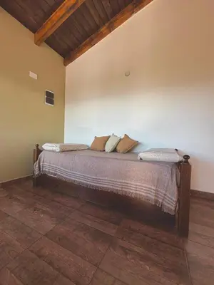 a bedroom with a bed with pillows on it at Green Valley Retreat in Villa General Belgrano