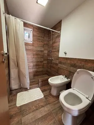 a bathroom with a toilet and a shower and a sink at Green Valley Retreat in Villa General Belgrano
