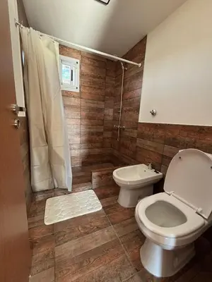 a bathroom with a toilet and a shower at Green Valley Retreat in Villa General Belgrano