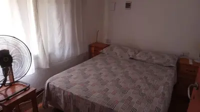 a bedroom with a bed and a fan and a window at casitadearminda-II in Villa de Las Rosas