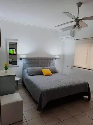 a bedroom with a bed with a yellow pillow on it at Villa Carlos Paz Inn in Villa Carlos Paz