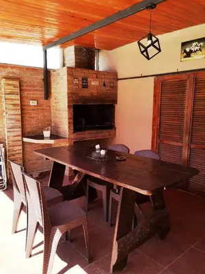 a dining room with a wooden table and chairs at Villa Carlos Paz Inn in Villa Carlos Paz