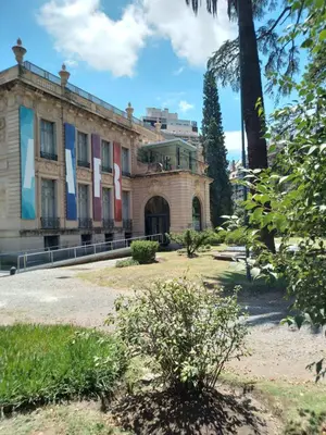 an old building with a palm tree in front of it at Departamento Plaza España in Cordoba
