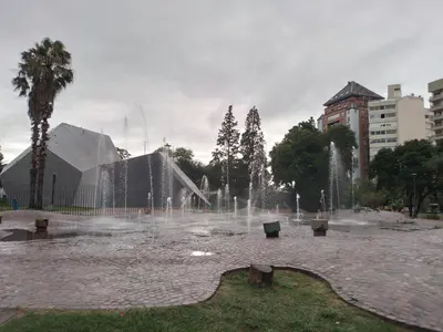 a fountain in a park with benches and buildings at Departamento Plaza España in Cordoba