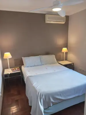 a bedroom with a white bed and two tables with lamps at Departamento Plaza España in Cordoba