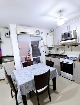 a kitchen with a table and chairs in a kitchen at beautiful apartment, two blocks from the pedestrian street in Villa Carlos Paz