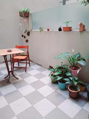 a room with a table and potted plants on the floor at beautiful apartment, two blocks from the pedestrian street in Villa Carlos Paz