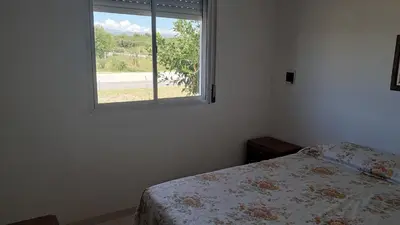a bedroom with a bed and a window at Departamento Alta Gracia in Alta Gracia