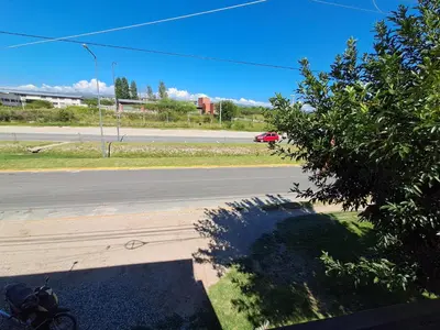 a view of a street with a red car on the road at Departamento Alta Gracia in Alta Gracia
