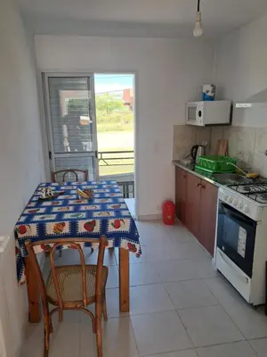a kitchen with a table with chairs and a stove at Departamento Alta Gracia in Alta Gracia
