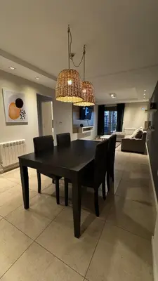 a black dining room table with chairs and a chandelier at Departamento centro Rio Cuarto con Cochera in Río Cuarto