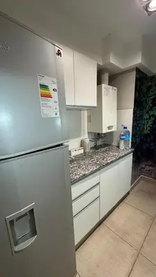 a kitchen with a stainless steel refrigerator and white cabinets at Departamento centro Rio Cuarto con Cochera in Río Cuarto