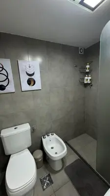 a bathroom with a white toilet and a shower at Departamento centro Rio Cuarto con Cochera in Río Cuarto