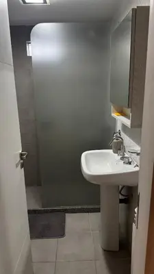 a bathroom with a white sink and a shower at Departamento centro Rio Cuarto con Cochera in Río Cuarto