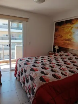 a bedroom with a bed and a large window at Departamento en Gral paz in Cordoba