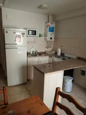 a kitchen with a white refrigerator and a table at Departamento en Gral paz in Cordoba