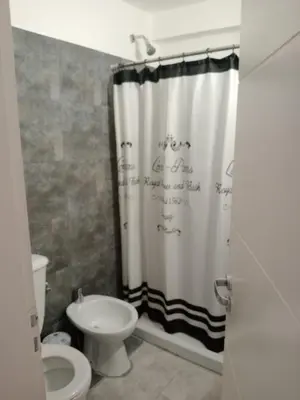 a bathroom with a shower curtain with writing on it at Departamento en Gral paz in Cordoba
