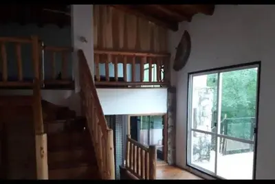 a living room with a staircase and a large window at Chalet de piedra y madera in Cordoba