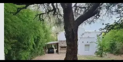a car parked in a driveway next to a white house at Chalet de piedra y madera in Cordoba