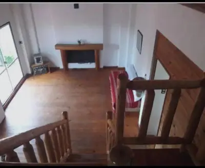 a room with a wooden staircase and a table at Chalet de piedra y madera in Cordoba