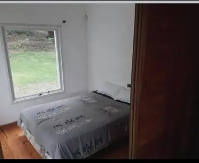 a bedroom with a bed and a window at Chalet de piedra y madera in Cordoba