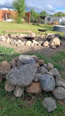 a pile of rocks on the grass near a park at Casa para 5 personas a 1 cuadra del río los Reartes in Villa Ciudad Parque