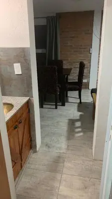 a bathroom with a sink and a table and chairs at Casa para 5 personas a 1 cuadra del río los Reartes in Villa Ciudad Parque