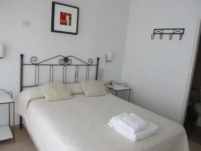 a bedroom with a white bed with two pillows at Faro del Parque in Cordoba