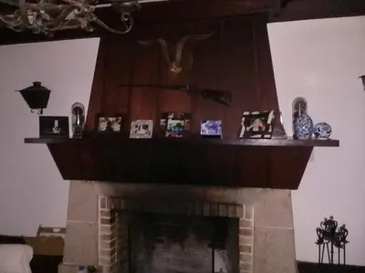 a brick fireplace with photos on top of it at Hotel San Huberto Tenis in Nono