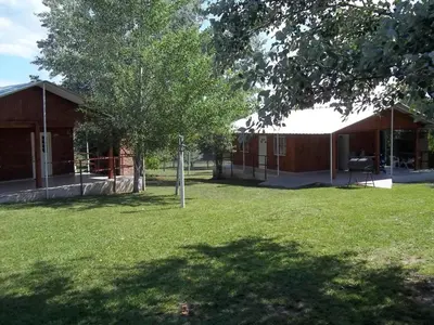 a building with a tree and a grass yard at La Matilde in Villa Ciudad de America
