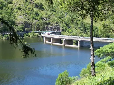 a bridge over a river with a bridge in the background at La Matilde in Villa Ciudad de America