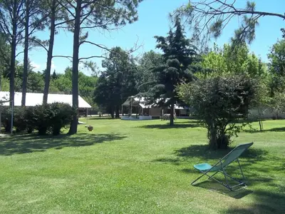a chair sitting in the grass in a yard at La Matilde in Villa Ciudad de America