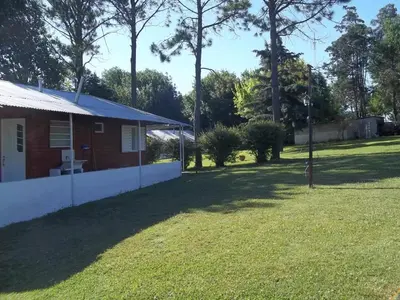 a house with a grass yard next to a building at La Matilde in Villa Ciudad de America