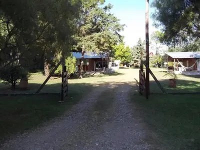 a dirt road with two gates in front of a house at La Matilde in Villa Ciudad de America