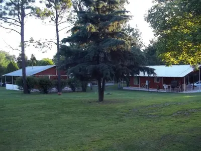 a red barn with a large tree in the yard at La Matilde in Villa Ciudad de America