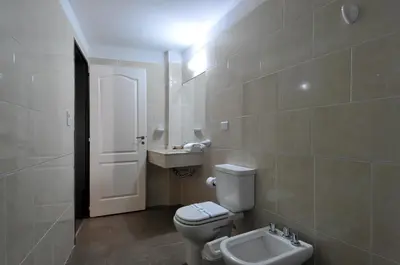 a bathroom with a toilet and a sink at Los Sauces Hotel & Spa in Villa Carlos Paz