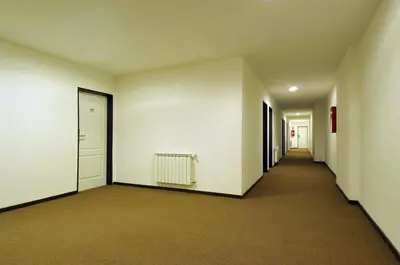an empty hallway with white walls and white doors at Los Sauces Hotel & Spa in Villa Carlos Paz