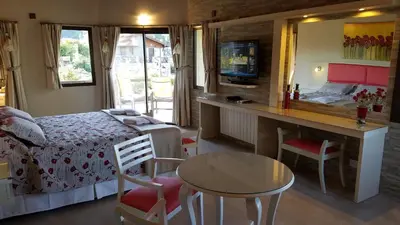 a bedroom with a bed and a desk and a table at Aires Serranos - Suites in La Cumbrecita