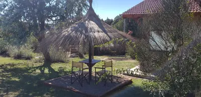 a hut with two chairs and a table in a yard at Aires Serranos - Suites in La Cumbrecita