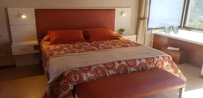 a bedroom with a large bed and a window at Aires Serranos - Suites in La Cumbrecita