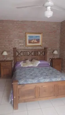 a bedroom with a large wooden bed with two night stands at Cabañas El Molinillo in Nono